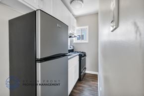 Long Beach apartment for rent - a kitchen with stainless steel appliances and white cabinets and a refrigerator