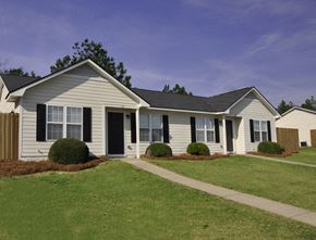 Fayetteville triplex for rent - a white house with black shutters and a lawn