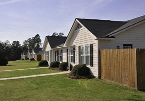Fayetteville triplex for rent - a row of houses on a lawn with a wooden fence