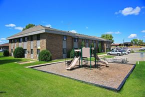 Buffalo apartment for rent - a playground in front of a brick building