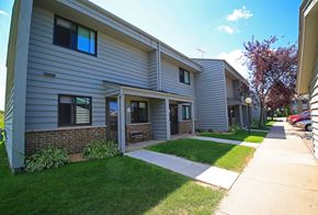 Buffalo apartment for rent - a sidewalk in front of a building with a lawn and grass