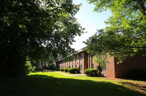 Delano apartment for rent - the side of a brick building with grass and trees