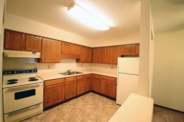 Monticello townhouse for rent - a kitchen with white appliances and wooden cabinets