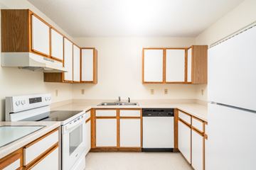 Eden Prairie townhouse for rent - A kitchen with white appliances and wooden cabinets.