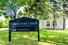 Eden Prairie townhouse for rent - A sign for Purgatory Creek Townhomes stands in front of a house.