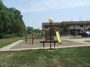 Young America townhouse for rent - a playground in a park in front of a building