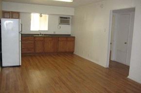 Austin apartment for rent - an empty kitchen with wooden floors and a refrigerator