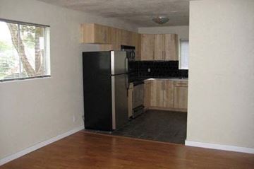 Austin apartment for rent - a kitchen with a black refrigerator and wooden cabinets