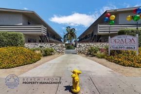 Anaheim apartment for rent - A yellow fire hydrant is in front of a sign for Beach Front Property Management.