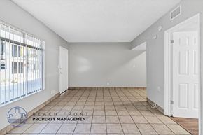 Anaheim apartment for rent - A spacious room with tile flooring and a large window overlooking the street.