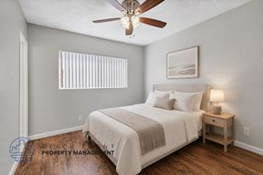 Anaheim apartment for rent - A bedroom with a bed, nightstand, and a ceiling fan.