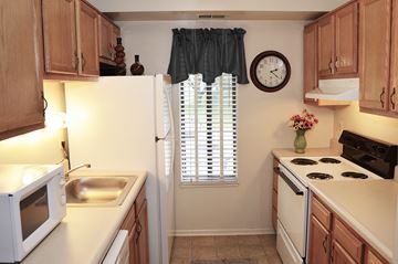 Timonium apartment for rent - A kitchen with wooden cabinets and a white refrigerator.
