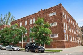 Chicago apartment for rent - a red brick building with cars parked in front of it