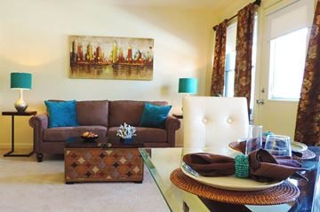 Parkville apartment for rent - A brown couch with blue pillows sits in a living room.
