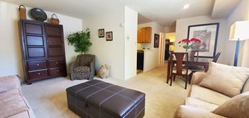 Glen Burnie apartment for rent - a living room with a leather ottoman and a dining room table