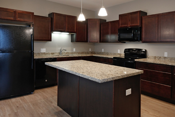 Grand Forks townhouse for rent - a kitchen with granite counter tops and dark wood cabinets