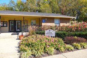 Nashville apartment for rent - a yellow building with a sign in front of a garden