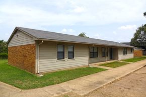 Gates apartment for rent - a small tan house with a sidewalk in front of it