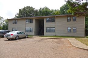 Gates apartment for rent - a large apartment building with cars parked in front of it