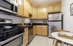 Chevy Chase apartment for rent - a kitchen with stainless steel appliances and wooden cabinets