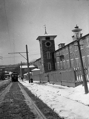 Baltimore apartment for rent - A black and white photo of a train on tracks with a building in the background.