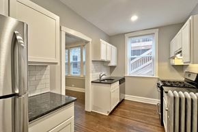 Oak Park apartment for rent - A kitchen with a black countertop and white cabinets.