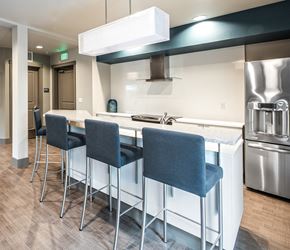 Bellevue apartment for rent - a kitchen with a bar and stools and a stainless steel refrigerator