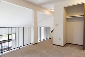 Grand Rapids apartment for rent - the upstairs living room of an apartment with a railing and a door to a balcony