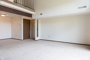 Grand Rapids apartment for rent - the living room of an empty house with white walls and a wooden door