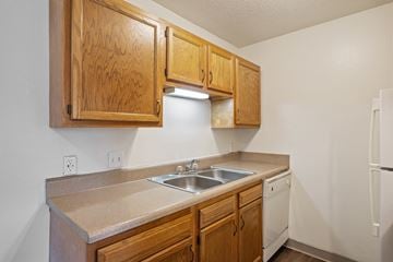 Wyoming apartment for rent - A kitchen with wooden cabinets and a white refrigerator.