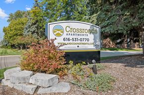Wyoming apartment for rent - A sign for Crossroads Apartments is displayed in front of some trees.