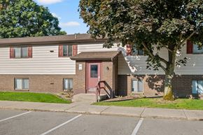 Wyoming apartment for rent - A tree in front of a building with a red door.