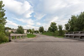 Hudsonville apartment for rent - A gravel road leads to a wooden gate.