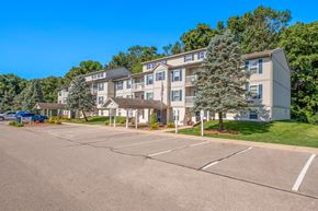 Allegan apartment for rent - A large apartment complex with a parking lot in front.