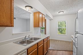 Holland apartment for rent - A kitchen with wooden cabinets and a white fridge.