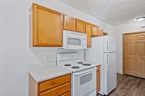 Holland apartment for rent - A kitchen with white appliances and wooden cabinets.