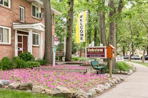 Grand Rapids apartment for rent - a sidewalk in front of a building with a sign and flowers