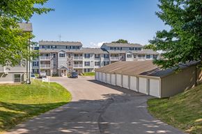 Wyoming apartment for rent - A road leads to a building with a garage door.