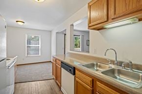 Wyoming apartment for rent - A kitchen with a white fridge, a white dishwasher, and a white sink.