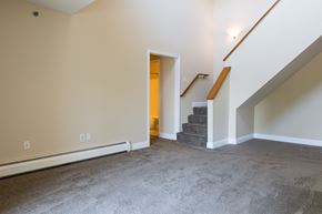 Wyoming apartment for rent - an empty living room with stairs and a carpeted floor