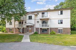 Wyoming apartment for rent - A two-story apartment building with a front lawn and trees.