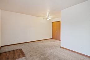 Wyoming apartment for rent - A room with a carpeted floor and a ceiling fan.