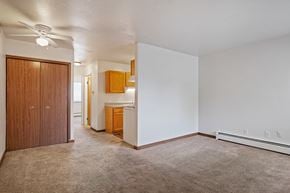 Wyoming apartment for rent - A room with a carpeted floor and a ceiling fan.