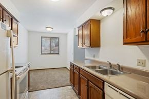 Grandville apartment for rent - A kitchen with a refrigerator, sink, and cabinets.