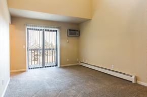 Grandville apartment for rent - an empty living room with a sliding glass door to a balcony