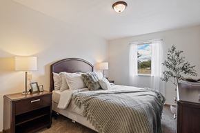 Grand Rapids apartment for rent - A bedroom with a large bed and a nightstand with a lamp.