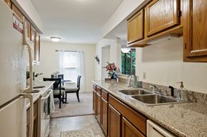 Comstock Park apartment for rent - A kitchen with wooden cabinets and a granite countertop.