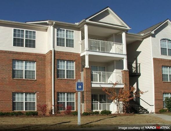 Atlanta apartment for rent - A blue sign with a white arrow pointing to the right is in front of a building.