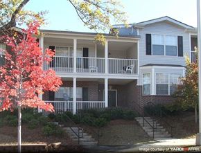 Atlanta apartment for rent - A tree with red leaves is in front of a two-story house.