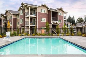 Vancouver apartment for rent - Pool with lounge chairs and apt buildings Vancouver, Washington | Copper Lane Apartments